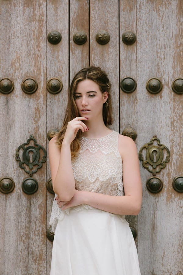 Bohemian bride standing against door