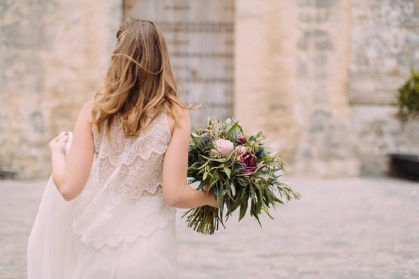 Boho bride holding rustic bouquet