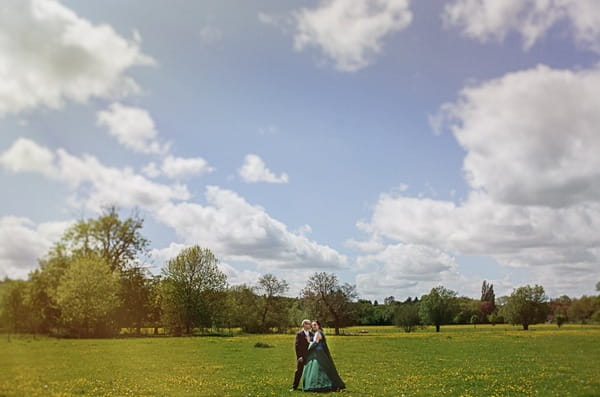 Bride and groom standing in field