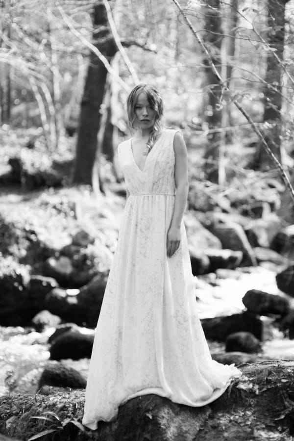 Bride standing by stream