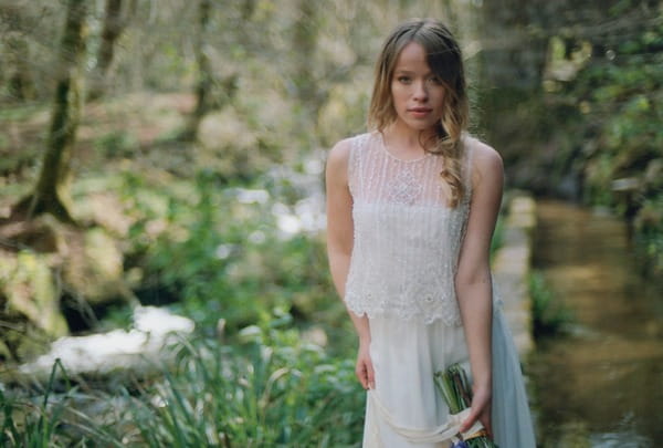 Bride in lace two-piece dress holding bouquet