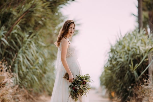 Boho bride holding rustic bouquet