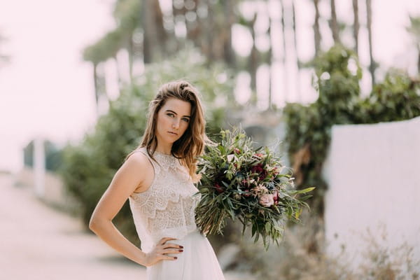 Bride holding rustic bouquet with hand on hip