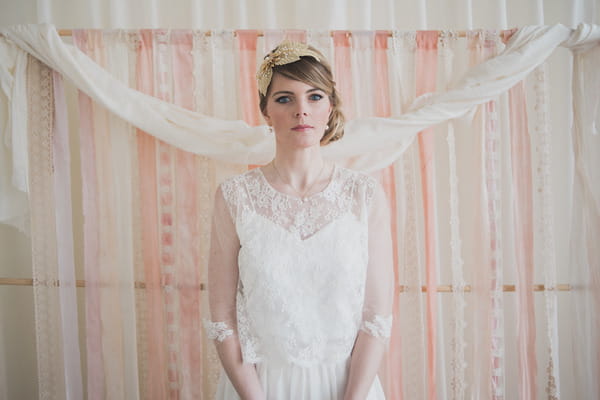 Bride standing in front of pink wedding ceremony backdrop