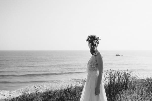 Boho bride with flower crown looking at sea