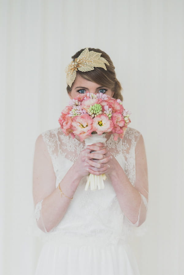 Bride holding pink bouquet in front of face