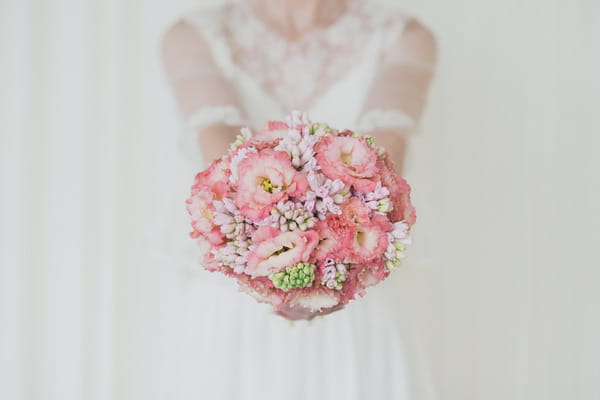 Bride holding out pink wedding bouquet