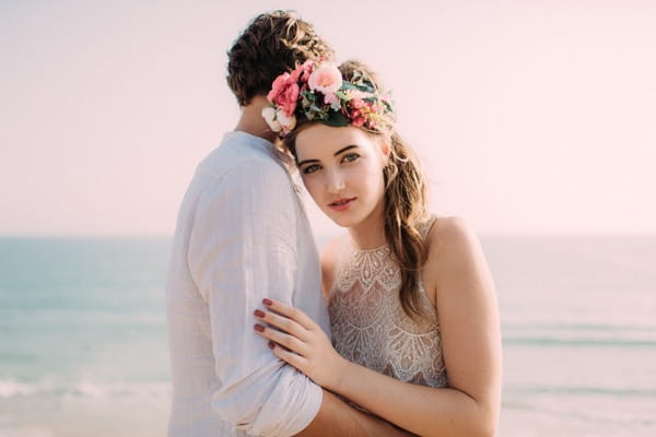 Boho bride wearing flower crown standing with groom