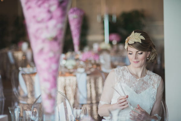 Bride sitting in chair at wedding table