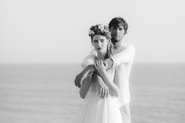 Groom with arms around boho bride