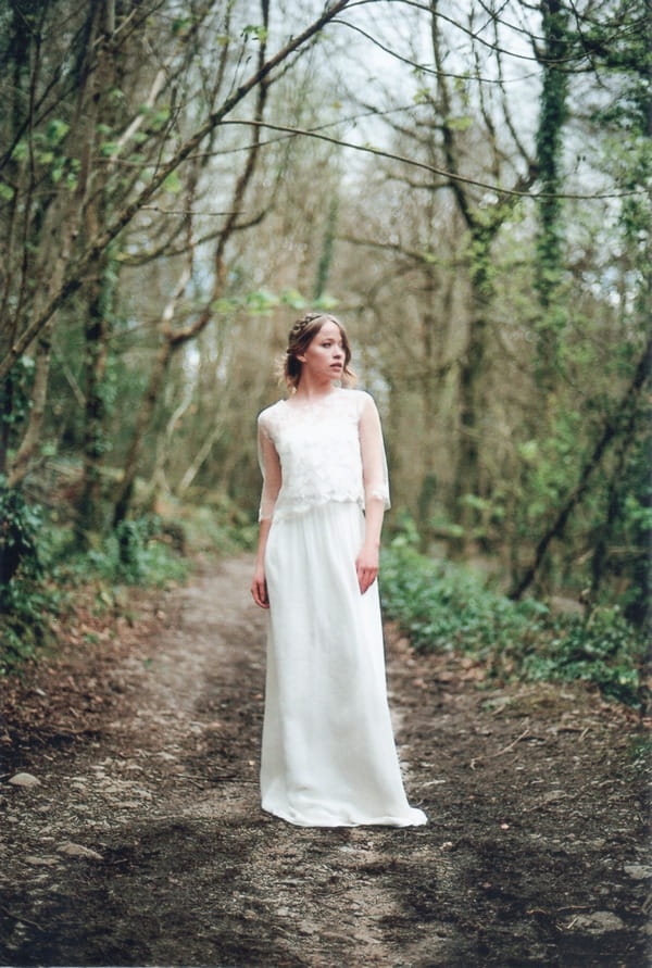 Bride standing in clearing in woodland