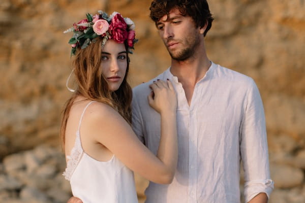 Groom looking at bride with flower crown