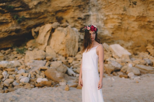 Bohemian bride wearing flower crown on beach