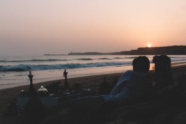 Bride and groom sitting on Spanish beach at night