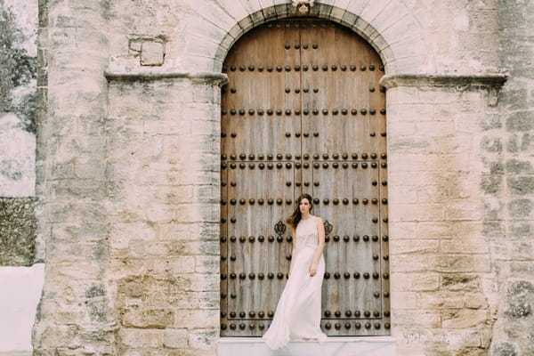 Bride standing up against large door