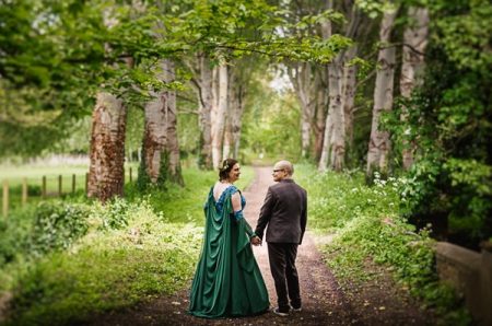 Bride and groom holding hands on path in woodland