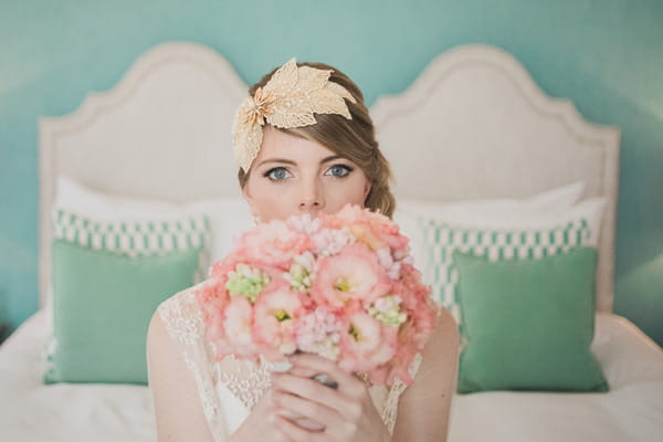 Bride holding pink bouquet in front of face