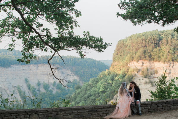 Bride and groom sitting on wall at Letchworth State Park
