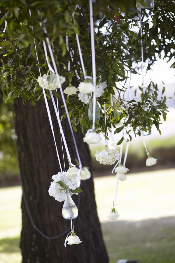 Vases of flowers hanging from tree