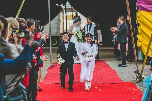 Pageboy and flower girl walking down aisle for circus wedding