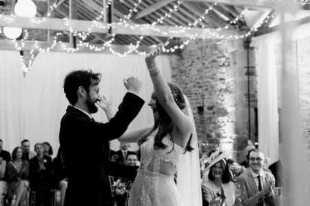 Happy bride and groom with arms in the air after getting married - Picture by Folega Photography