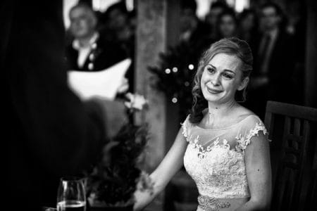 Emotional bride listening to wedding speech - Picture by Neale James