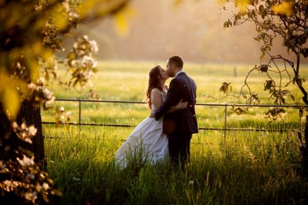 Bride and groom kissing in long grass - Picture by Alex Toze