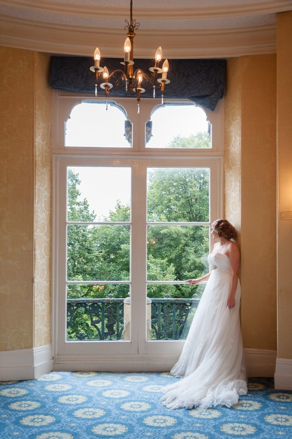 Bride looking out of the window of The Duke of Cornwall Hotel