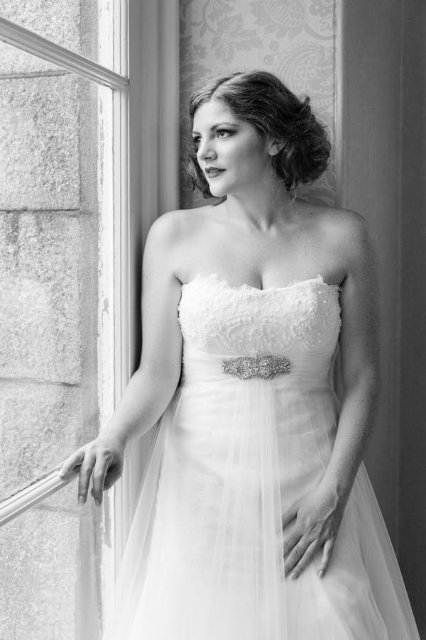 Bride standing by window at The Duke of Cornwall Hotel