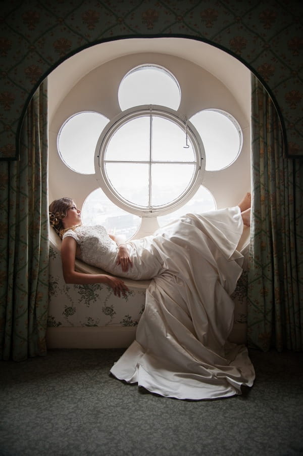 Bride laying in flower window at The Duke of Cornwall Hotel
