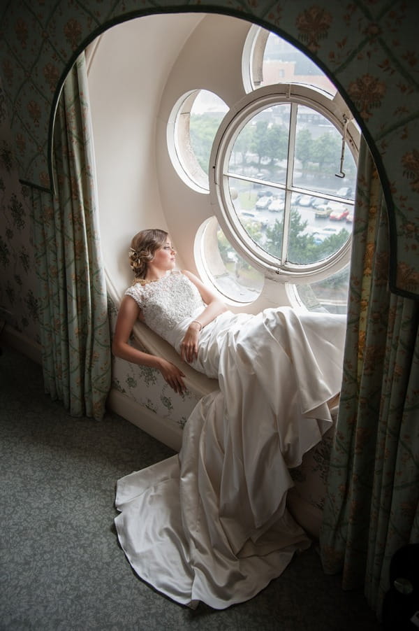 Bride laying in flower window at The Duke of Cornwall Hotel