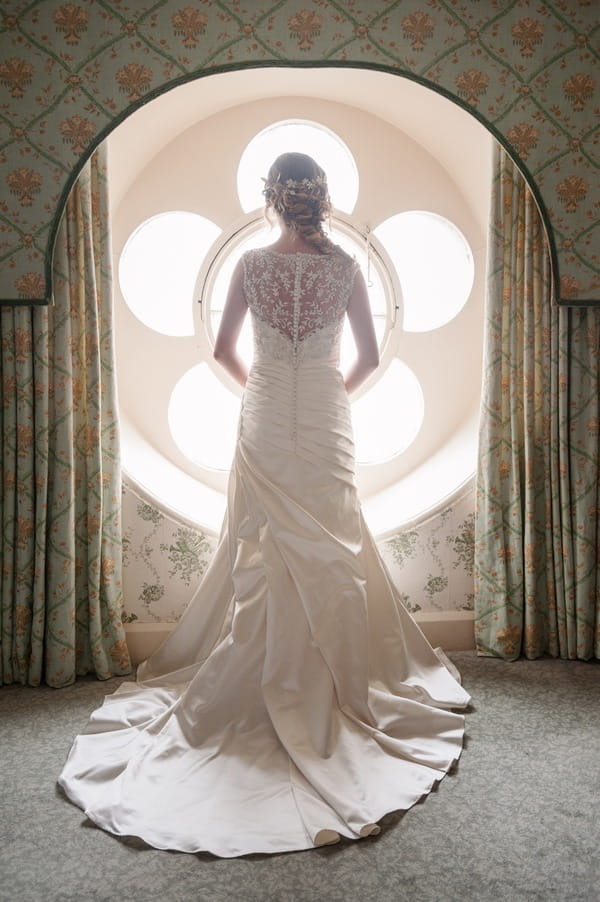 Bride looking out of flower window at The Duke of Cornwall Hotel