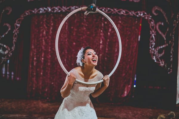 Bride poking head through trapeze hoop