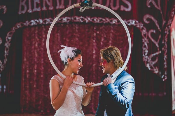 Bride and groom holding trapeze hoop