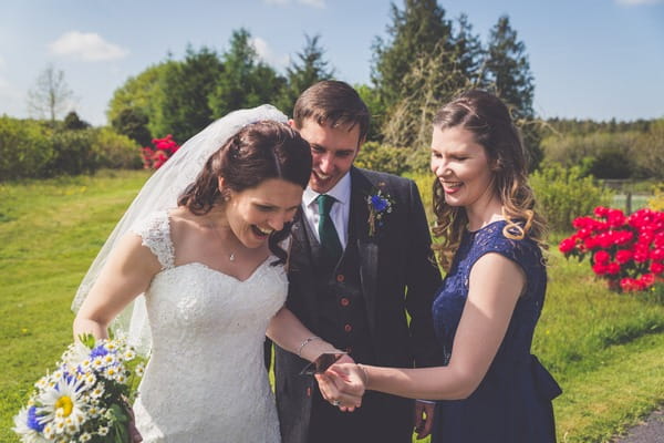 Wedding guest showing bride and groom a picture