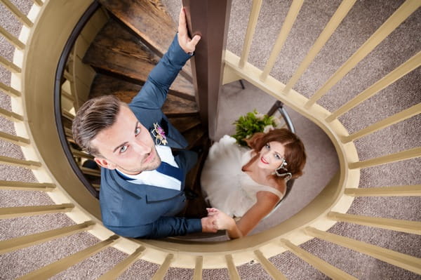 Bride and groom standing on the spiral staircase at The Duke of Cornwall Hotel