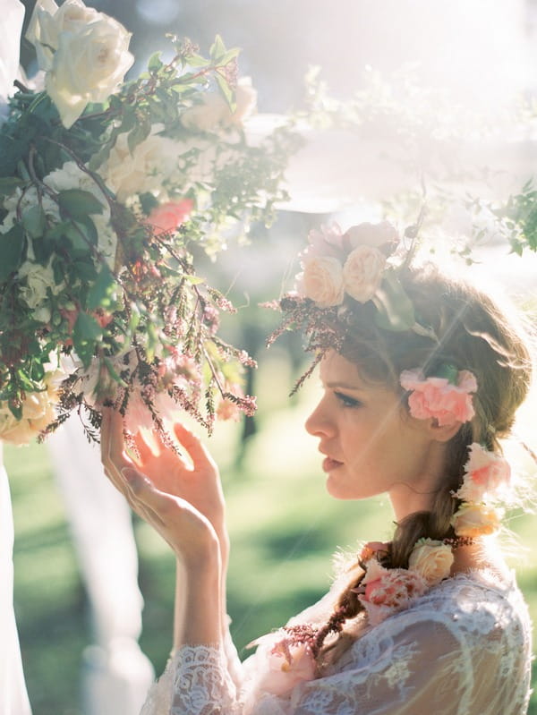 Bohemian bride looking closely at flowers