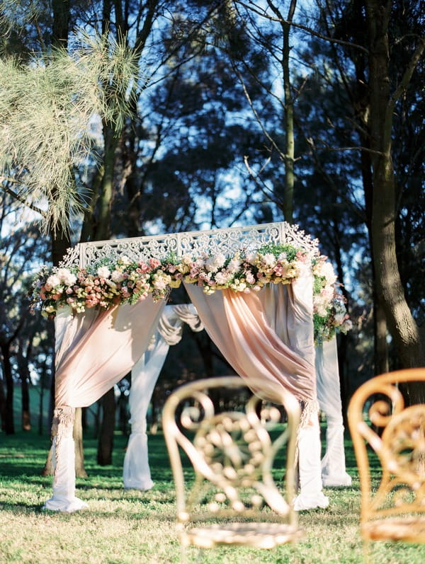 Elegant outdoor ceremony structure with flowers and drapes