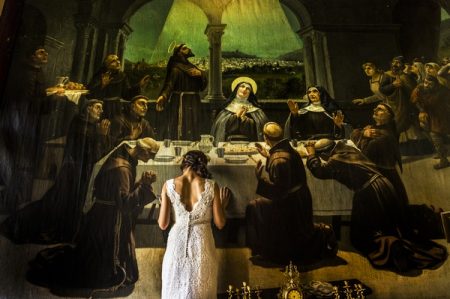 Bride standing up against religious painting - Picture by Augustin Regidor