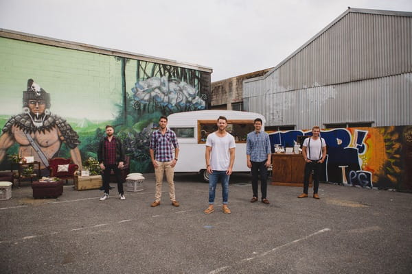 Men standing in front of caravan bar