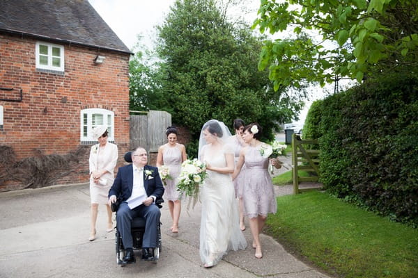 Bride and bridesmaids walking with bride's father to wedding ceremony at Packington Moor