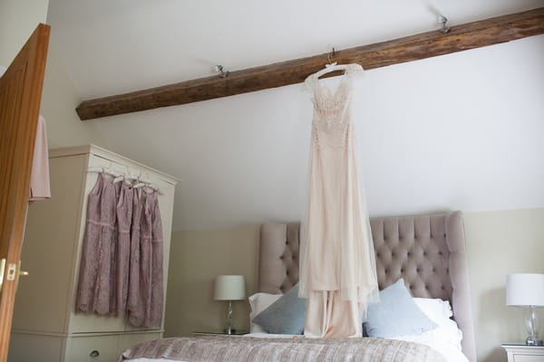 Wedding dress hanging from beam in cottage at Packington Moor