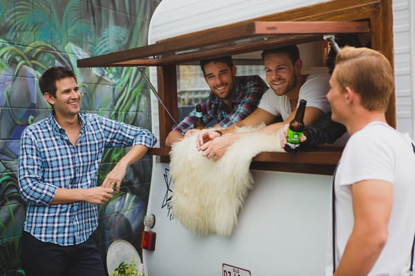 Men leaning on caravan bar