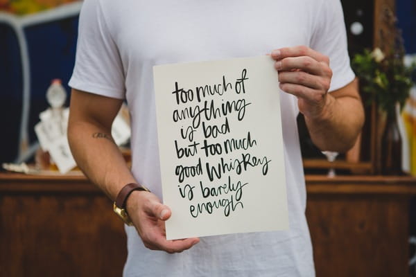 Man holding whisky quote sign