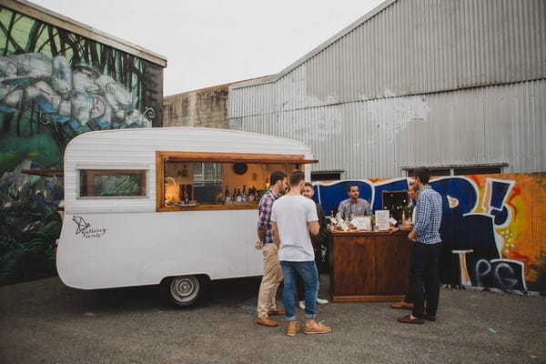 Men drinking whisky by caravan bar