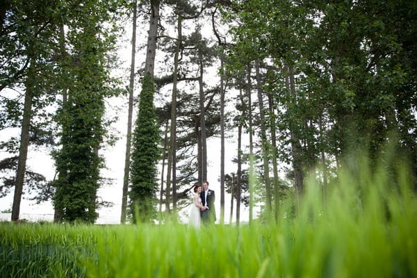 Bride and groom in front of tall trees at Packington Moor