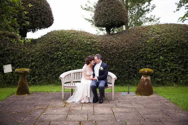 Bride and groom sitting on bench at Packington Moor