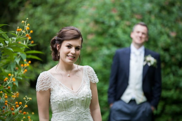Bride with groom out of focus in background