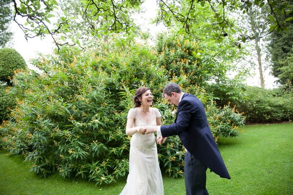 Bride and groom laughing in grounds of Packington Moor