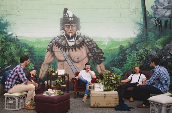 Men sitting in cool, urban setting with wall art